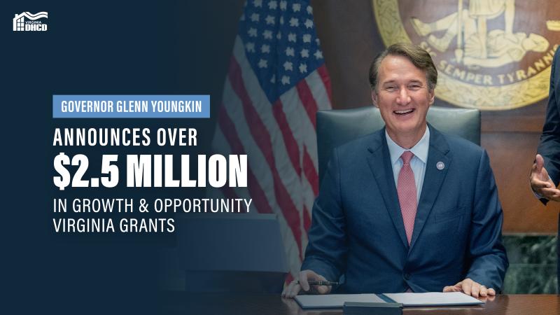 A picture of Gov. Glenn Youngkin wearing a blue suit and red tie, smiling at the camera about to sign legislature - white text reads :Governor Glenn Youngkin Announces over $2.5 Million in Growth and Opportunity Virginia Grants"